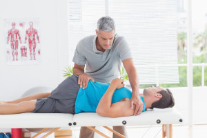 bigstock-physical-therapist-stretching-lower-back-man-85571219-300x200